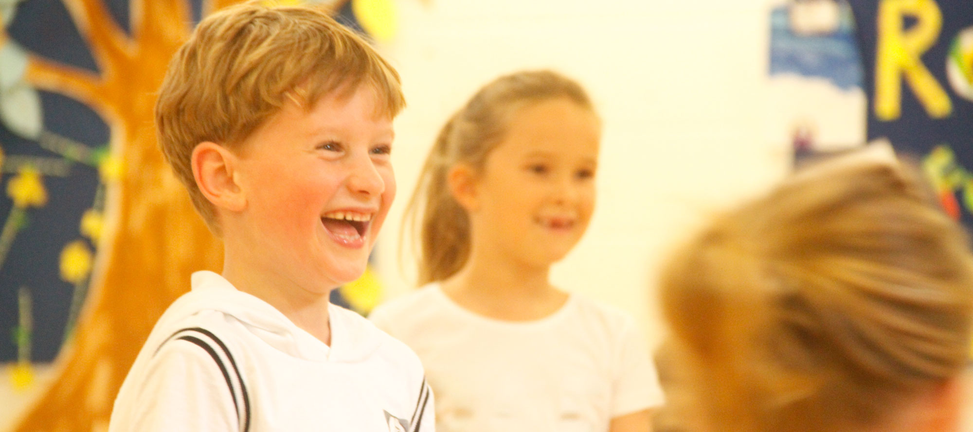 Year 3 pupils laughing together during a dance activity