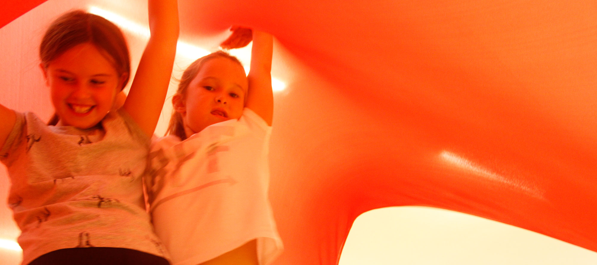Year 4 pupils moving underneath a sweeping red stretch cloth